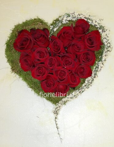 Composizione a forma di cuore con rose di colori assortiti.